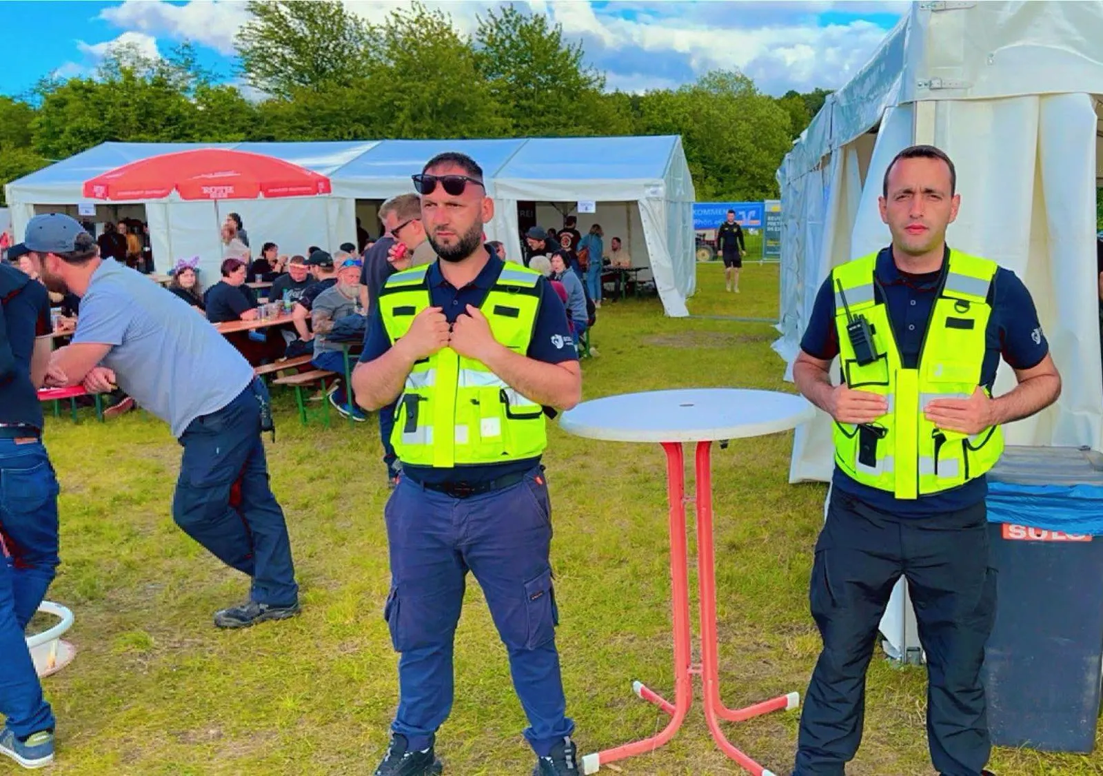 Zwei Sicherheitskräfte von Square Security auf einem Festgelände mit Zelten